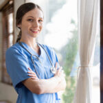Portrait Of A Friendly Female Doctor Or Nurse Wearing Blue Scrub