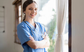 Portrait Of A Friendly Female Doctor Or Nurse Wearing Blue Scrub
