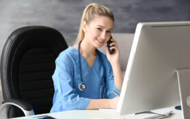 Young,Medical,Assistant,Talking,By,Telephone,While,Working,In,Office