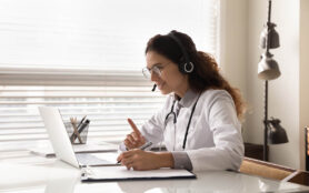 Happy,Attentive,General,Practitioner,In,Headset,Using,Laptop,,Giving,Online