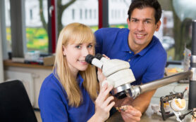 Apprentice,And,Dental,Technician,Look,At,Prosthesis,Under,A,Microscope