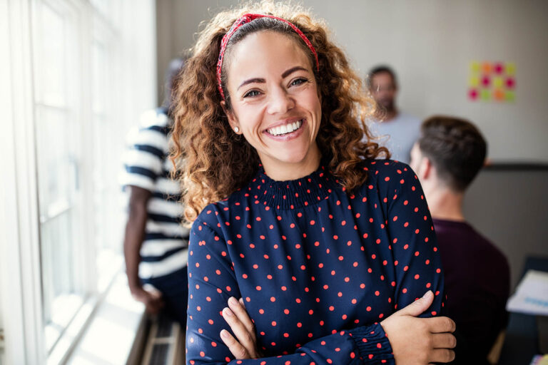 Young,Female,Designer,Smiling,While,Standing,With,Her,Arms,Crossed