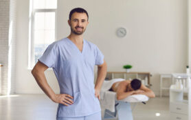 Young,Smiling,Confident,Man,Professional,Chiropractor,Masseur,Standing,And,Looking