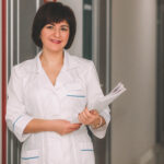 Adult,Happy,Female,Doctor,Is,Standing,With,Smile,With,Documents