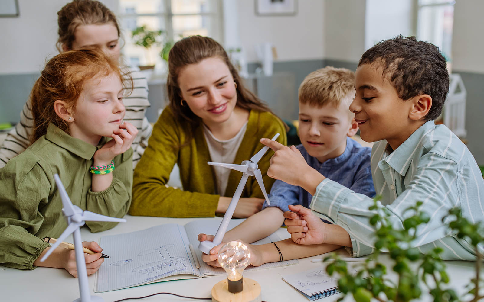 Young,Teacher,With,Model,Of,Wind,Turbine,Learning,Pupils,About