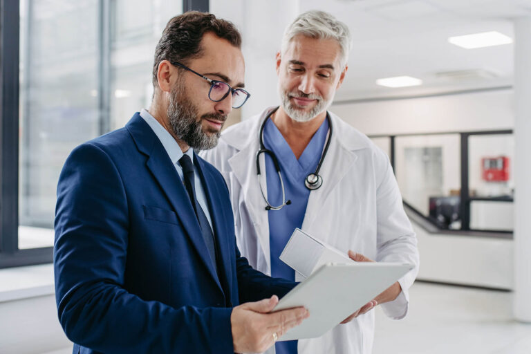 Pharmaceutical,Sales,Representative,Talking,With,Doctor,In,Medical,Building,,Presenting