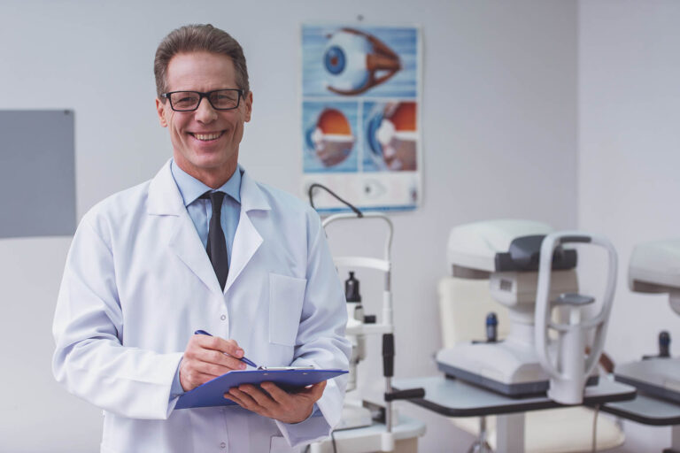 Handsome,Middle,Aged,Ophthalmologist,Making,Notes,And,Smiling,While,Standing