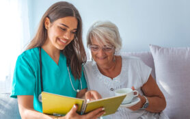 Young,Caregiver,And,Senior,Woman,Laughing,Together,While,Sitting,On