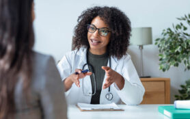 Shot,Of,Beautiful,Cheerful,Female,Doctor,Talking,While,Explaining,Medical