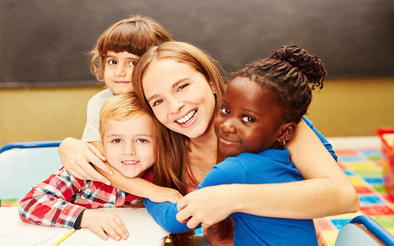 Happy,Children,Hug,Their,Childminder,In,Child,Care