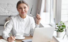 Elegant,Mature,Female,Psychologist,Working,In,Modern,Office,,Holding,Eyeglasses